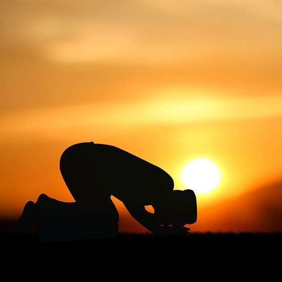 Person making dua at sunrise